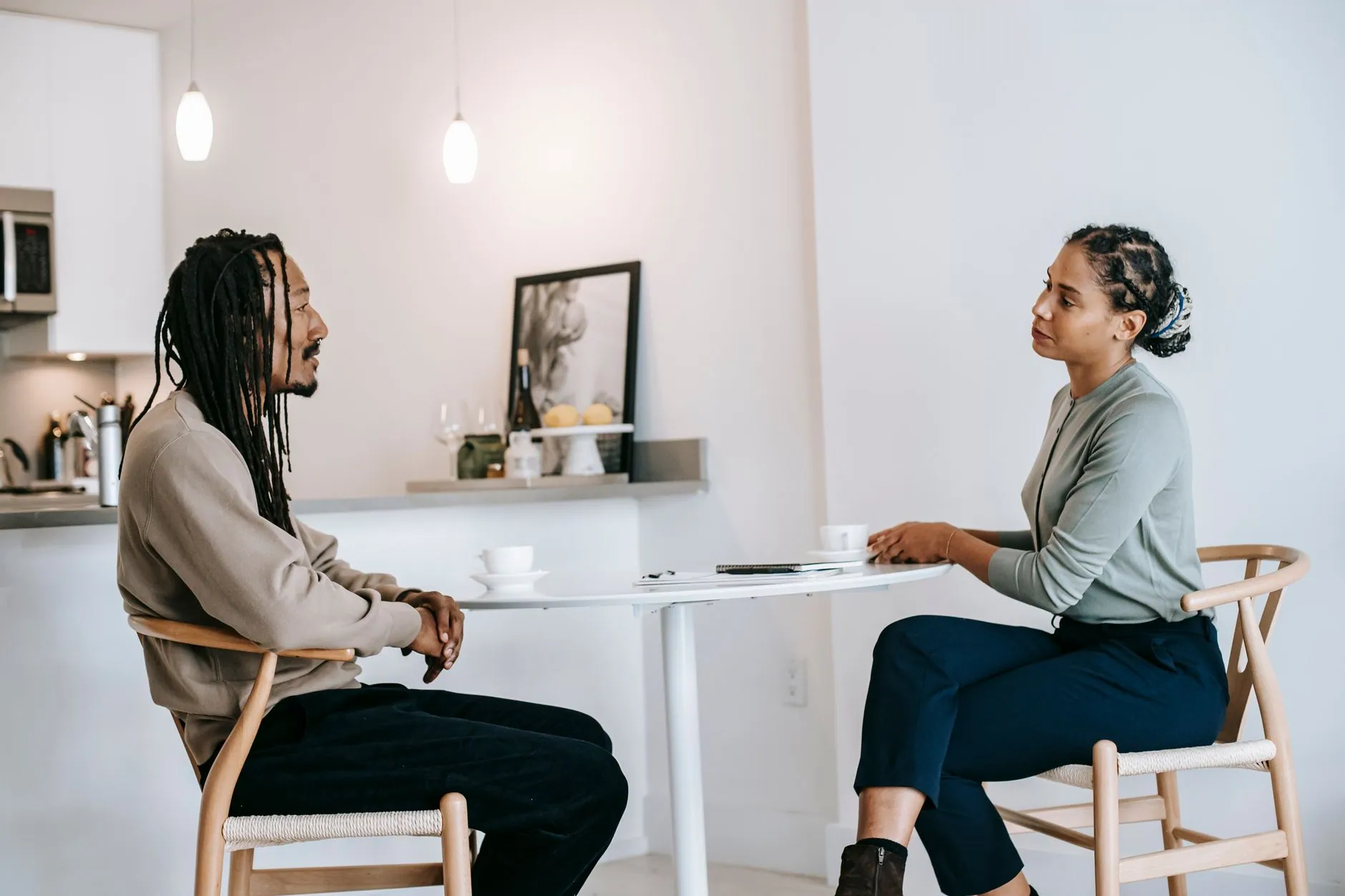 Two colleagues talking across a small table in a bright room