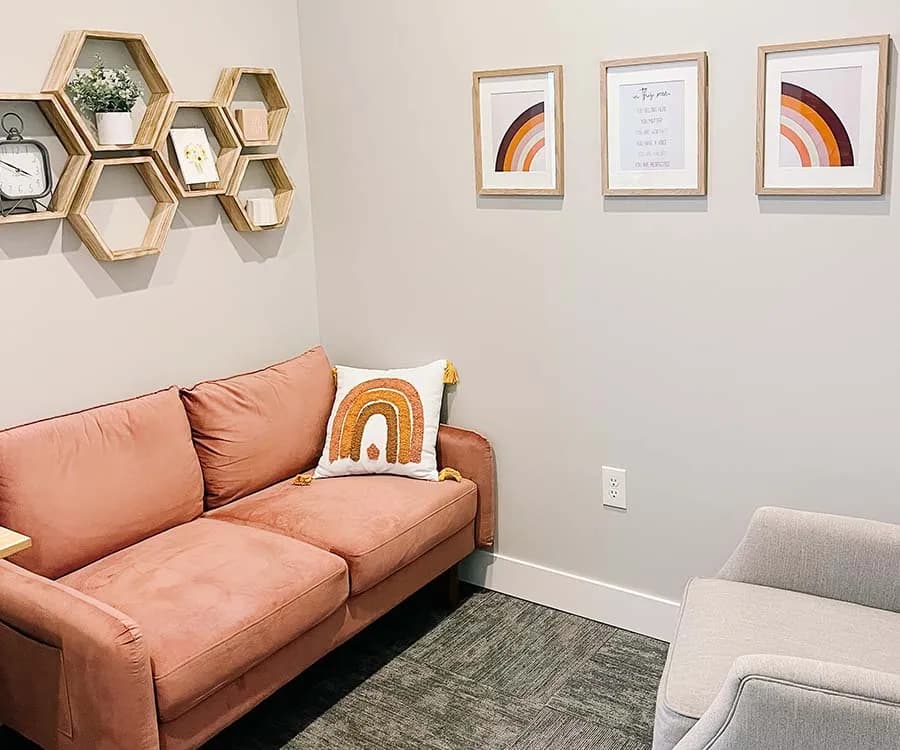 A Mountain View Family Therapy room with a coral sofa and framed prints