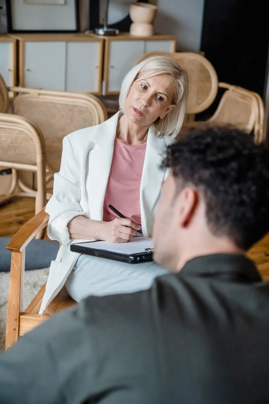 A woman taking notes while another person talks